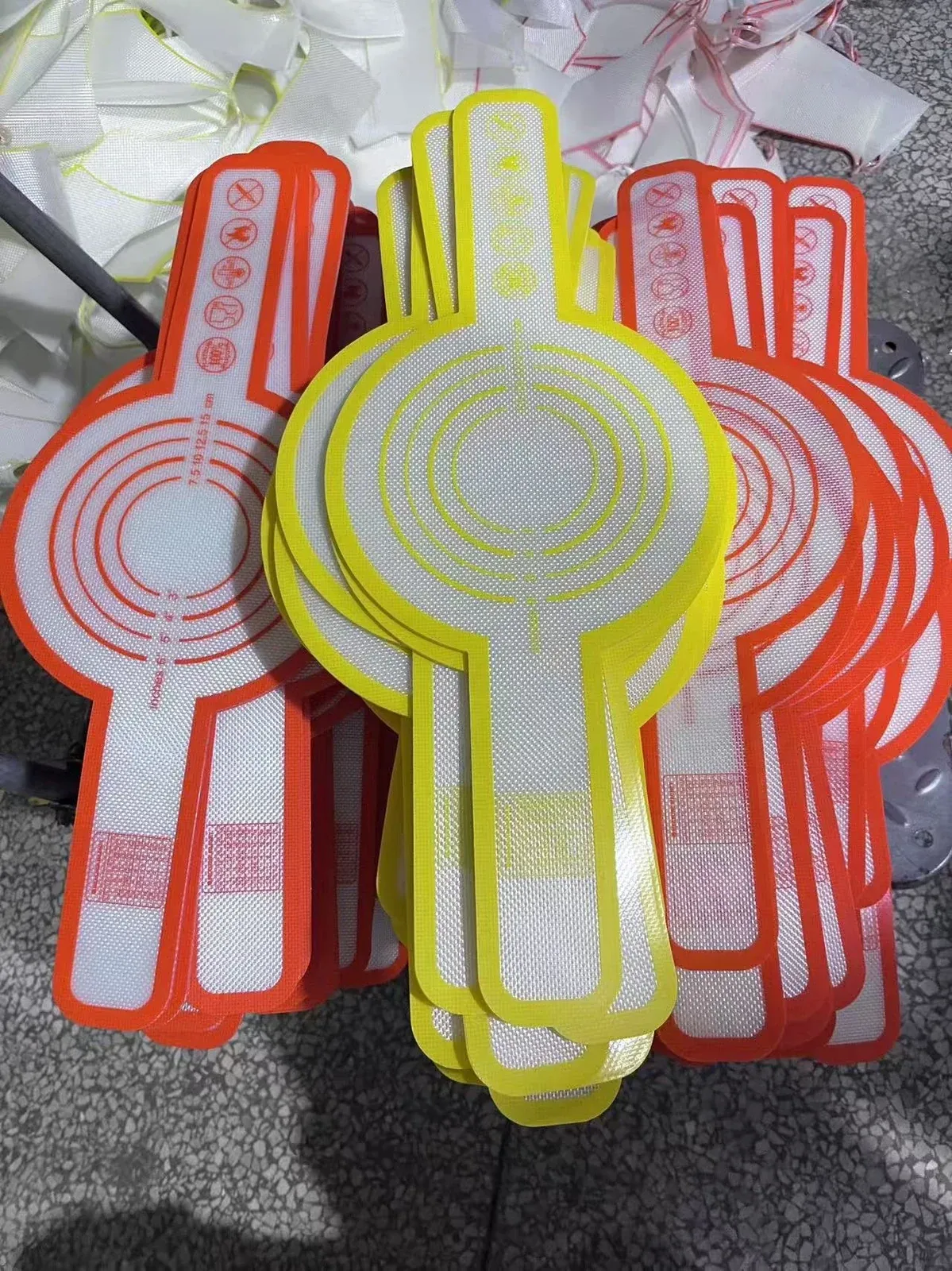 Red and yellow custom shaped silicone mats with lifting tabs and printed guides