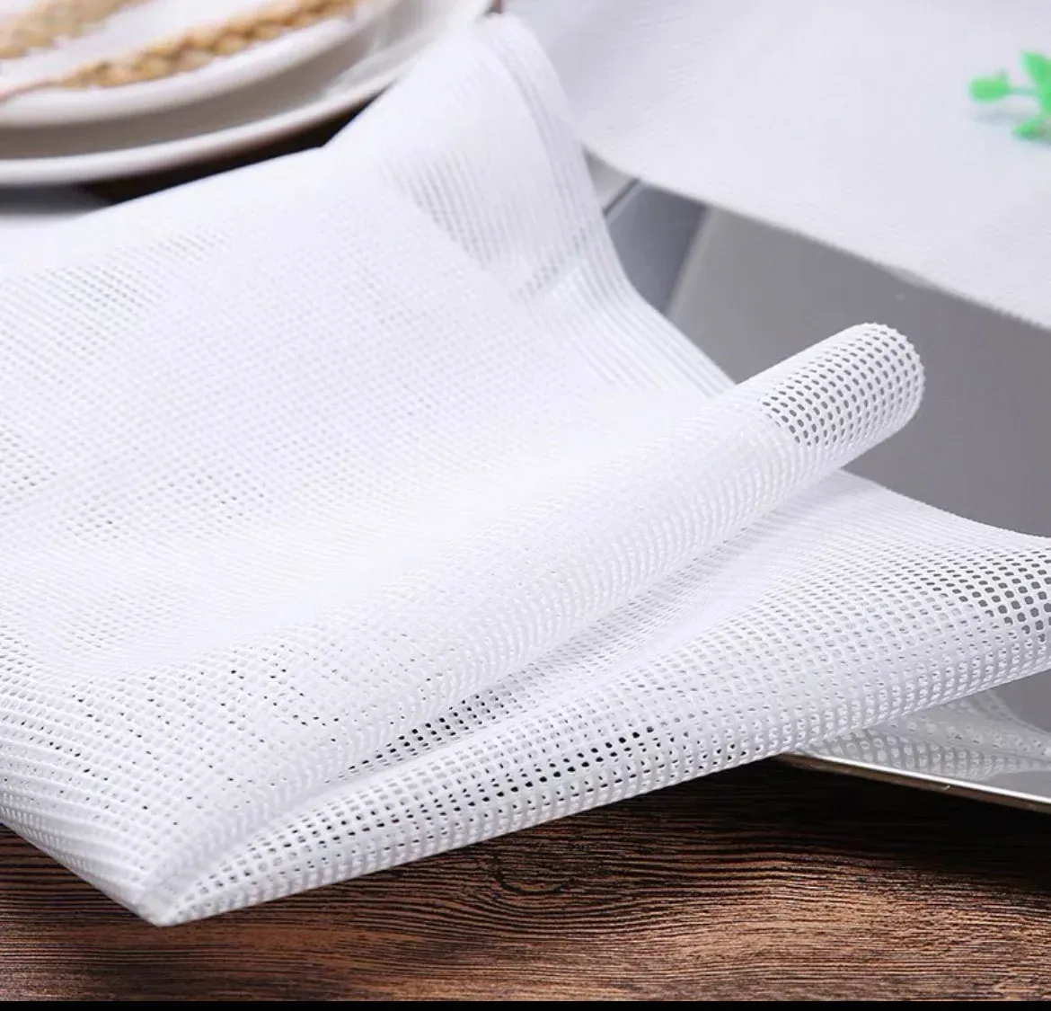White silicone mesh sheets with flexible cut edges on a wooden surface