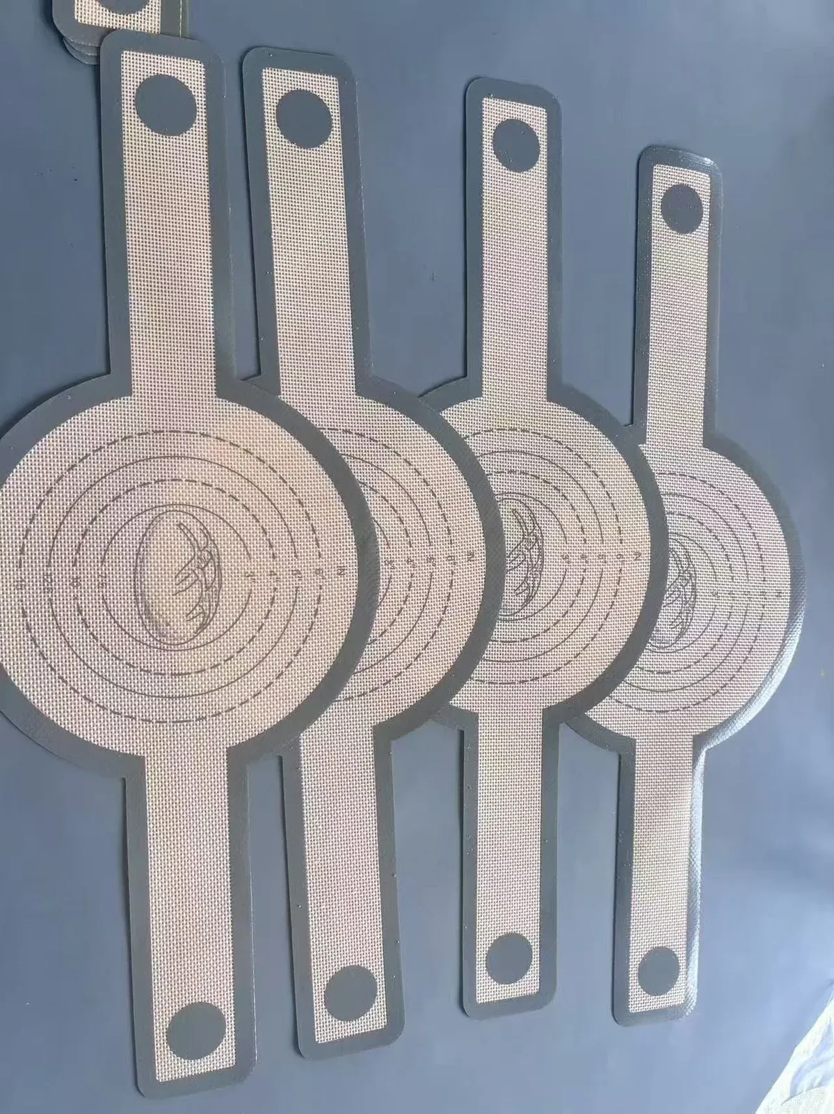 Round silicone fiberglass mats with long lifting tabs and printed concentric circles