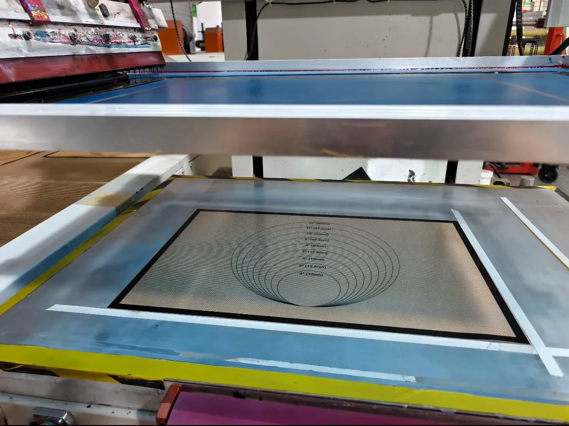 Silicone fiberglass mat with concentric pastry measurement guides on a screen-printing production table